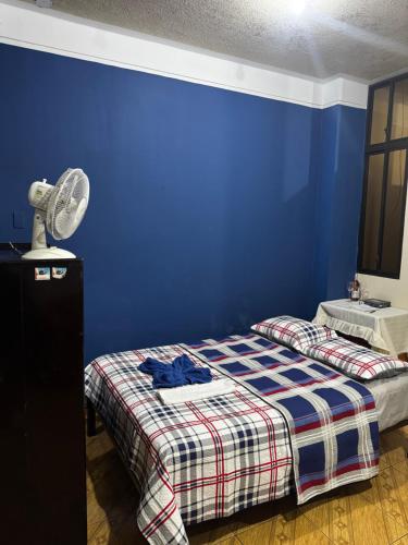 a blue bedroom with a bed and a fan at Mini Suite en el centro de la ciudad in Macará