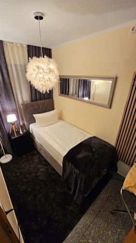 a bedroom with a bed and a large chandelier at Soho Guesthouses in Düsseldorf