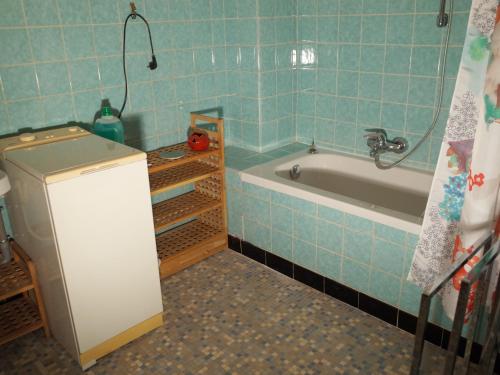 a blue tiled bathroom with a tub and a sink at Maison de Jeanne in Eschau
