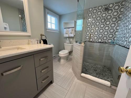 a bathroom with a shower and a toilet and a sink at Beach Breeze Inn in Falmouth