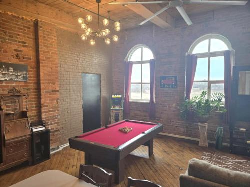 a room with a pool table in it with windows at Detroit Riverwalk Loft in Detroit