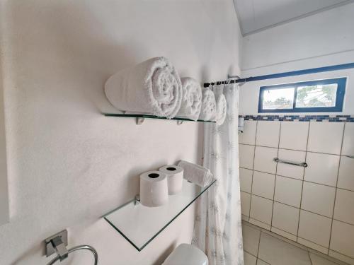 a bathroom with a toilet and towels on a wall at Casa Celeste Rio Grande #2 in Puntarenas