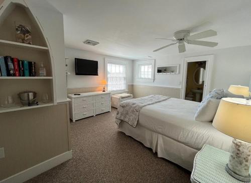 a bedroom with a bed and a ceiling fan at Beach Breeze Inn in Falmouth