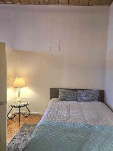 a bedroom with a bed and a table with a lamp at Detroit Riverwalk Loft in Detroit