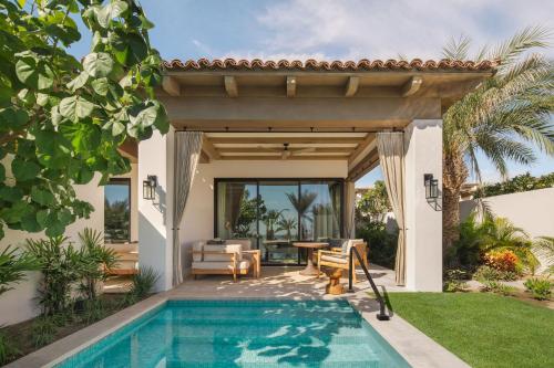 an outdoor patio with a swimming pool and a house at Four Seasons Resort Cabo Del Sol in El Tule