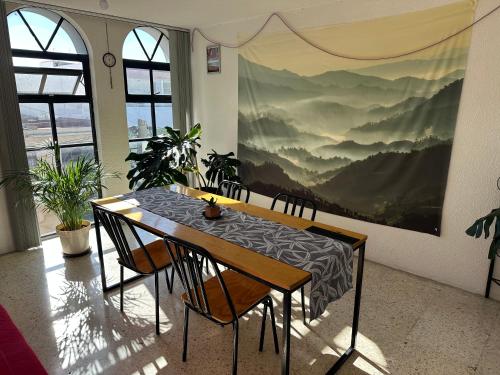 a dining room with a table and chairs and a painting at Departamento céntrico compartido in Pachuca de Soto