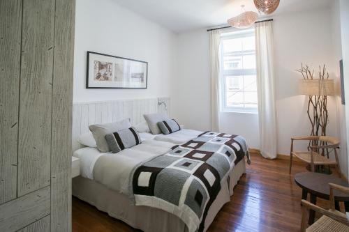 a bedroom with a bed with a black and white blanket at Casa Galos Hotel & Lofts in Valparaíso