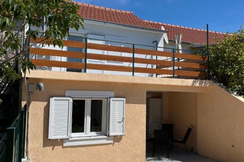 a building with white shutters and a window at Holiday house with a parking space Bilice, Krka - 24006 in Šibenik