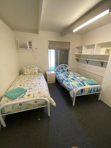 a room with two beds and a window at Akubra Downs, Yeppoon -Cottage 3 bedroom in Cawarral