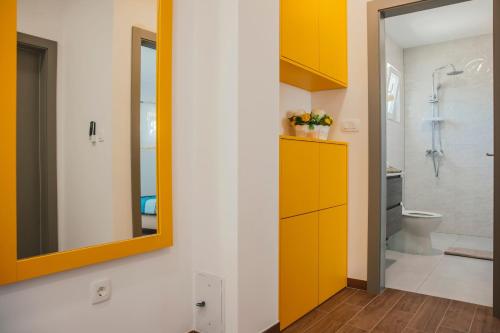 ein Badezimmer mit gelben Schränken und einem Spiegel in der Unterkunft Holiday house with a parking space Gornji Prolozac, Zagora - 24024 in Gornji Proložac
