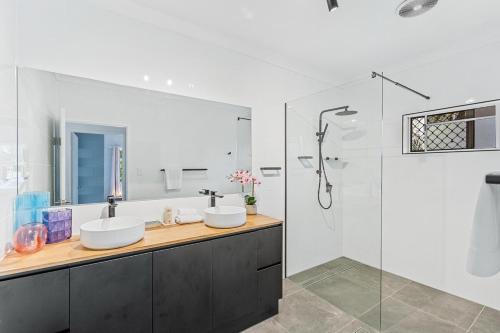 a bathroom with two sinks and a shower at 4 Bedroom House at Holloways Beach in Holloways Beach