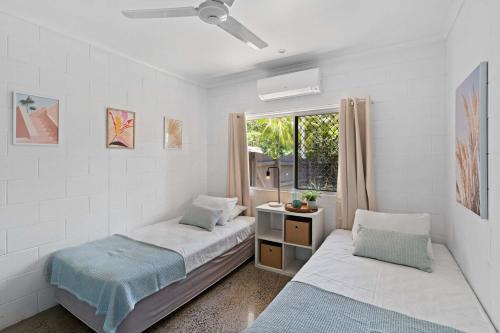 a bedroom with two beds and a window at 4 Bedroom House at Holloways Beach in Holloways Beach