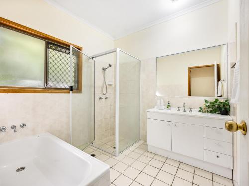 a bathroom with a tub and a shower and a sink at Spacious Land Area 5Bedroom Home at Sunnybank New AC in Brisbane