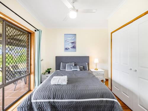a bedroom with a bed and a large window at Spacious Land Area 5Bedroom Home at Sunnybank New AC in Brisbane