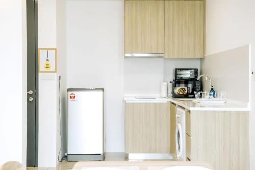 a small kitchen with a refrigerator and a sink at Tropicana 218 Macalister Penang in George Town