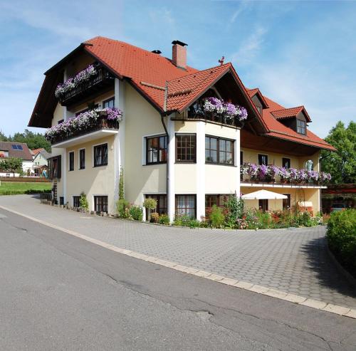 a house with flowers on the side of a road at Gästehaus Am Sonnenhang in Erbendorf