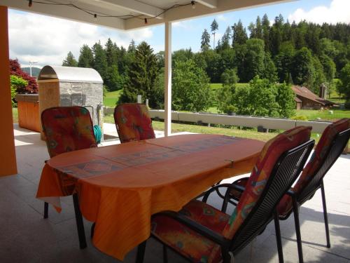 a wooden table and chairs on a patio at Residenza San Remy in Unterkulm