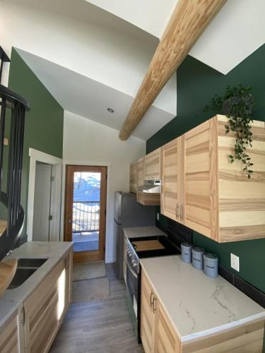 a kitchen with wooden cabinets and a green wall at Alder House in Golden