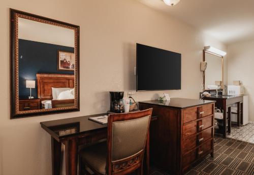 a hotel room with a desk and a mirror at Water Front Inn in Port Townsend
