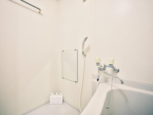 a white bathroom with a shower and a mirror at vetta kumamoto suizenji 403 in Kumamoto
