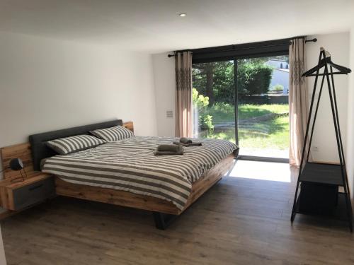 une chambre avec un lit et une grande fenêtre dans l'établissement Maison 3 chambres 900 m plage, à Lacanau