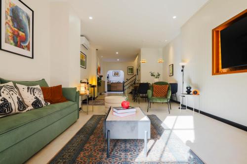 a living room with a green couch and a table at Sea Breeze Villa Patong in Patong Beach