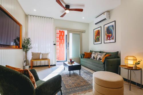 a living room with a green couch and a table at Sea Breeze Villa Patong in Patong Beach