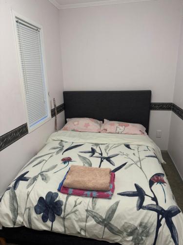a bedroom with a bed with a black headboard at Cozy room in Pokeno