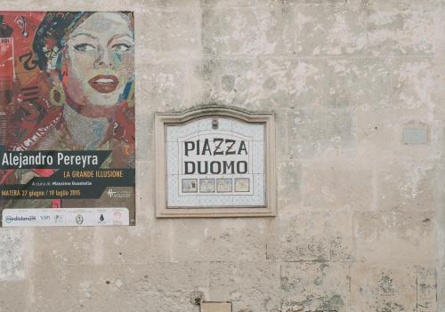 a painting of a woman on a wall with a sign at I Sassi Di Teopista in Matera