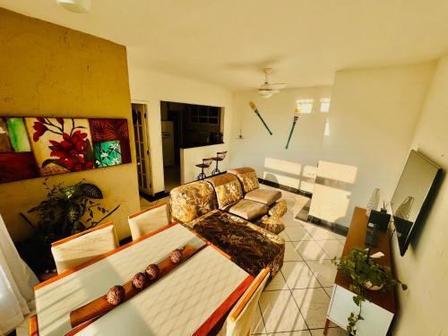 a living room with a couch and a table at Apartamento em Guarujá - Praia da Enseada in Guarujá