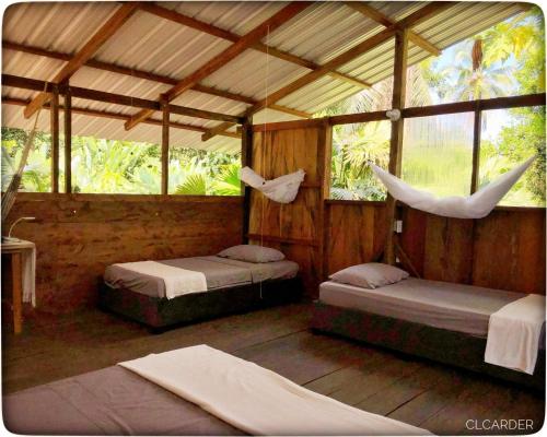 a room with two beds and hammocks in it at Cabaña Espavé - Arusí, Chocó in Nuquí