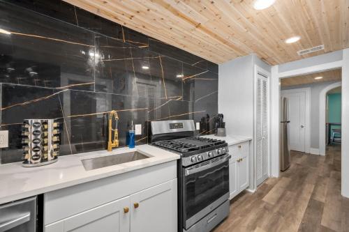 a kitchen with a stove and a sink at Quirky & Chic 3BR in Montrose - Perfect for Families & Groups in Houston