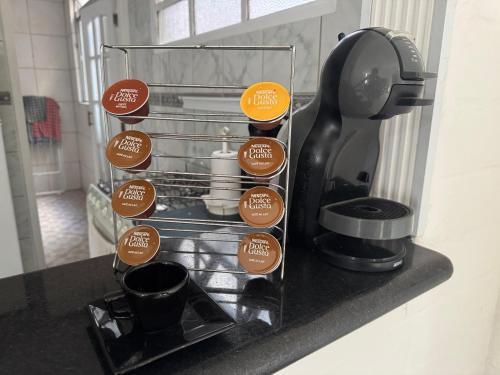 a counter with stickers on a coffee maker at Apartamento em Guarujá - Praia da Enseada in Guarujá