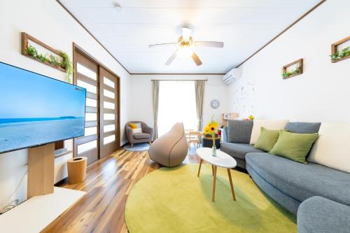 a living room with a couch and a tv at Casa Familia Aoshima in Miyazaki