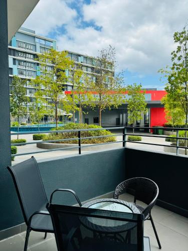 a balcony with chairs and a table and a building at Core Soho Suites Kota Warisan Sepang KLIA Airport Free Wifi by BKA LEGACY in Sepang