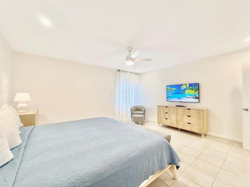 a bedroom with a bed and a dresser and a tv at Crystal Cove Sapphire Beach - Spacious Condo, Pool Tennis WiFi in East End