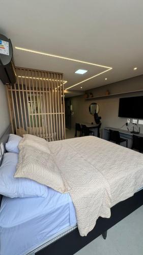 a bedroom with a large bed with a wooden headboard at Vert House in João Pessoa