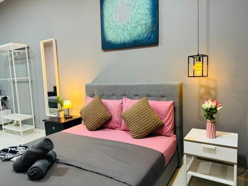 a bedroom with a bed with pink pillows at Core Soho Suites Kota Warisan Sepang KLIA Airport Free Wifi by BKA LEGACY in Sepang