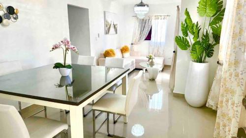 a dining room with a glass table and white chairs at Residencial El Molino 1 - 3 bedrooms 2 bathrooms in Concepción de La Vega