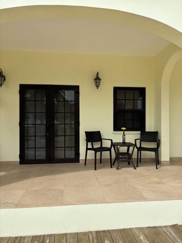 a room with two chairs and a table in a building at Paradise Inn Placencia in Placencia Village