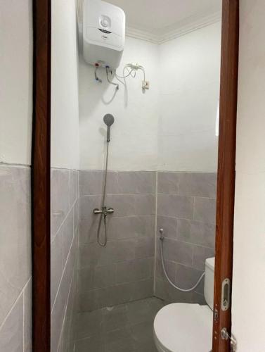 a bathroom with a shower and a toilet in it at Laika Homestay in Gondowulung
