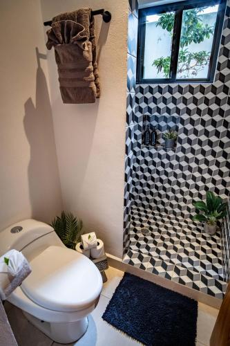 a bathroom with a toilet and a window and a shower at Aqua Viva, Pool, AC, Internet, Beach club in Bacalar