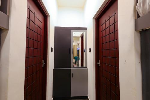 a hallway with two doors and a mirror at The Cozy Winterfell in Munnar