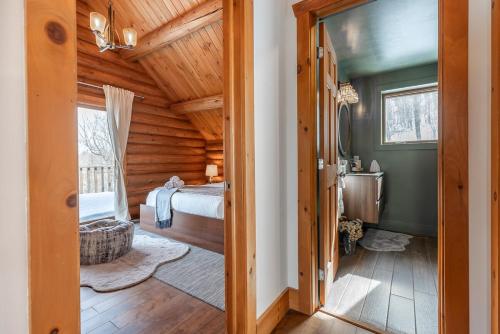 a bedroom in a log cabin with a bed and a sink at Chalet du Lac Rougeaud in Mont-Blanc