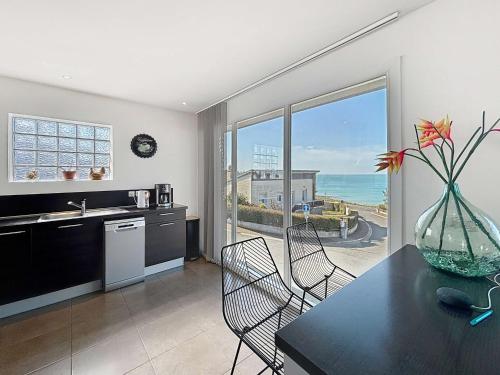 - une cuisine avec une table à manger et une vue sur l'océan dans l'établissement Villa à 150m de la plage avec piscine et WiFi gratuit - FR-1-361-8, à Donville-les-Bains