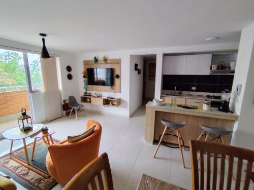 a kitchen and living room with chairs and a table at Mallorca Samaria Apartment in Ibagué