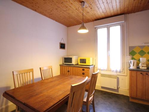 une cuisine avec une table en bois et un micro-ondes dans l'établissement Appartement F3 Mont-Dore à 200m des thermes, parking sécurisé, 4 couchages, sans ascenseur - FR-1-415-61, à Le Mont-Dore