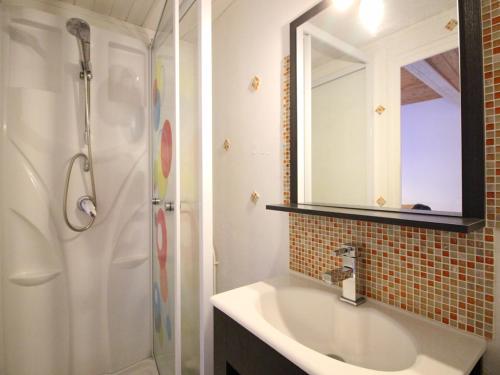 une salle de bain avec un lavabo, une douche et un miroir dans l'établissement Appartement F3 Mont-Dore à 200m des thermes, parking sécurisé, 4 couchages, sans ascenseur - FR-1-415-61, à Le Mont-Dore