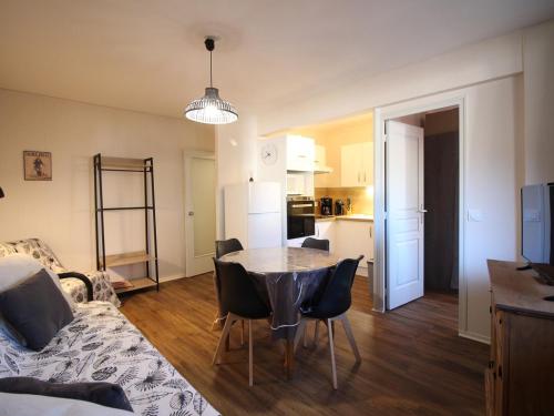 un salon avec une table et des chaises et une cuisine dans l'établissement Appartement F2 avec Parking Privé, Loggia et Ascenseur - Proche Thermes et Commodités - FR-1-415-135, à Le Mont-Dore