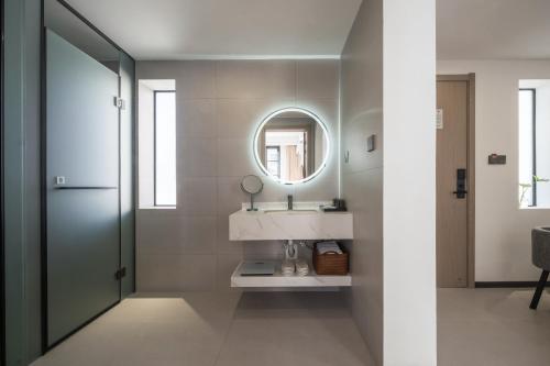 a bathroom with a sink and a mirror at Lane Wisdom Garden Hotel - Lijiang Ancient City Zhongyi Market in Lijiang